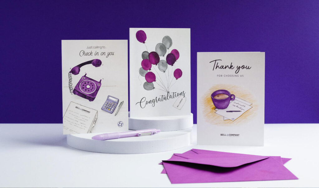 A set of three illustrated company greeting cards, with personalised company logo. The branded greeting cards include a congratulations card with an image of colourful balloons, a thank you card with an image of a mug and note, and a checking-in card, with an image of a phone calling.
